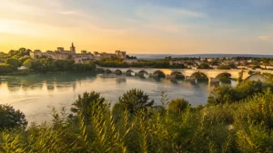 Panoramic view connecting Avignon and Sauveterre across the Rhône, with historic architecture, a bridge, and a peaceful villa