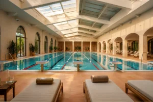 Vue intérieure d'une piscine couverte municipale avec plusieurs lignes d'eau sous une verrière lumineuse, ambiance calme et s